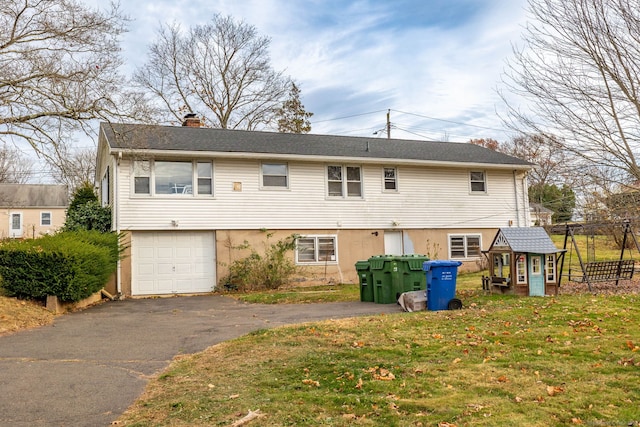 rear view of house with a garage and a lawn