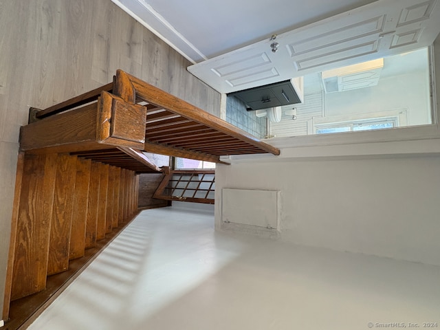 stairway with wood walls and concrete floors