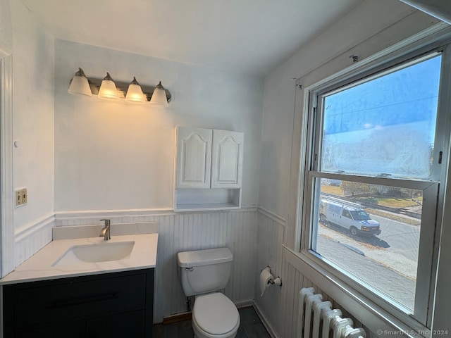 bathroom with vanity, toilet, and radiator