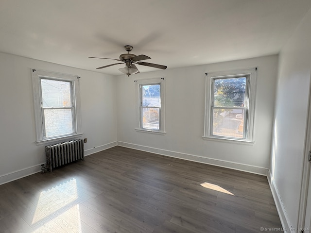 unfurnished room featuring dark hardwood / wood-style floors, plenty of natural light, and radiator heating unit