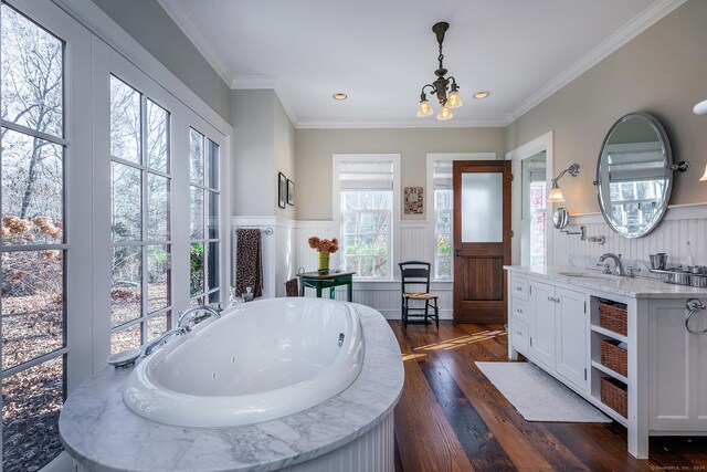 bathroom featuring a bathtub, vanity, crown molding, wood-type flooring, and an inviting chandelier