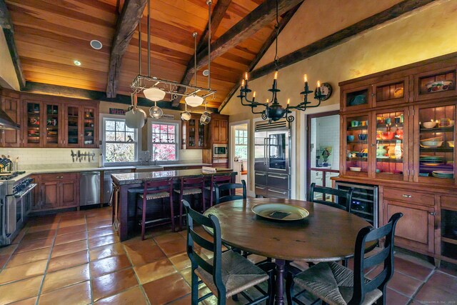 kitchen with wood ceiling, a chandelier, stainless steel appliances, and beam ceiling