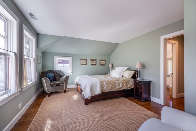 bedroom with dark hardwood / wood-style flooring and lofted ceiling