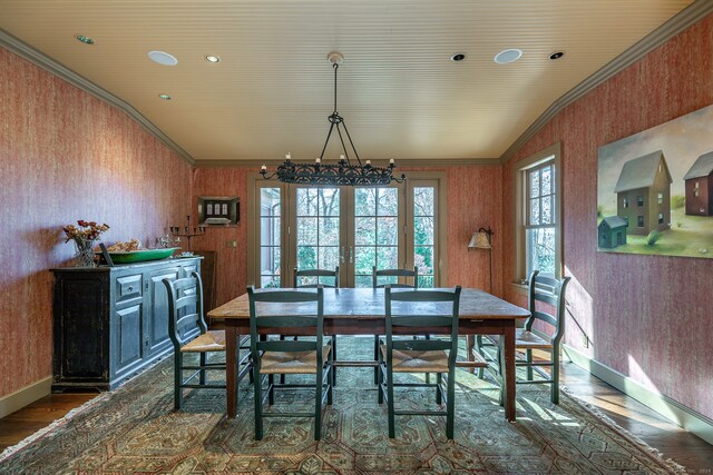 dining room with french doors, dark wood-type flooring, vaulted ceiling, and ornamental molding