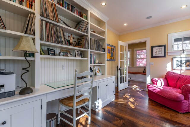 home office featuring dark hardwood / wood-style floors, built in desk, and ornamental molding