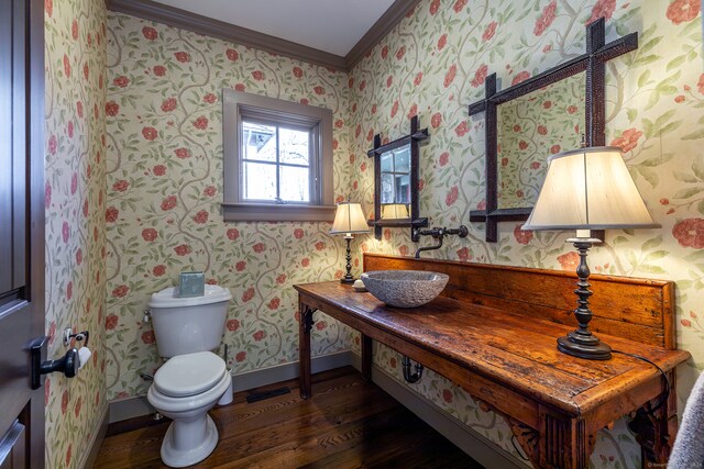 bathroom with hardwood / wood-style flooring, toilet, ornamental molding, and sink