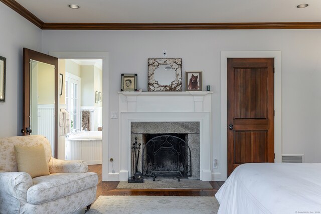 bedroom with crown molding, hardwood / wood-style floors, and ensuite bathroom