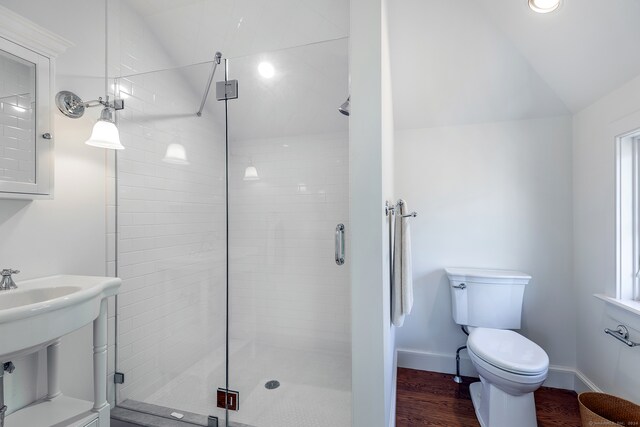 bathroom featuring a shower with shower door, wood-type flooring, vaulted ceiling, and toilet