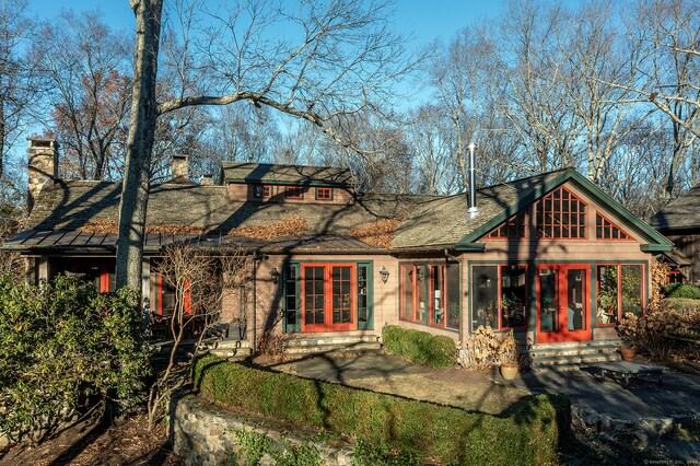 rear view of property featuring a sunroom