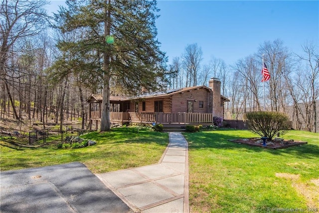 view of front of house with a wooden deck and a front lawn