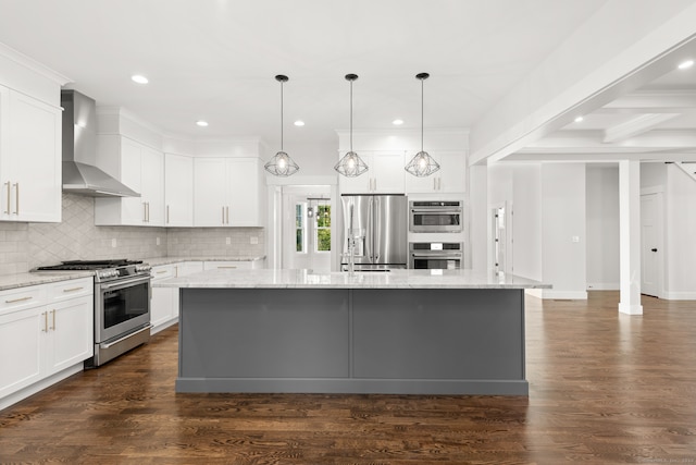 kitchen with stainless steel appliances, light stone counters, an island with sink, wall chimney range hood, and dark hardwood / wood-style flooring