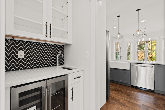 bar with beverage cooler, dishwasher, hanging light fixtures, gray cabinetry, and white cabinetry