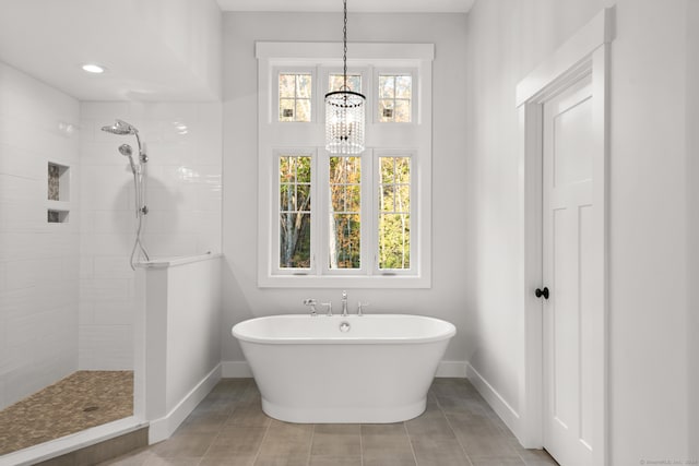 bathroom with tile patterned flooring, a notable chandelier, and plus walk in shower