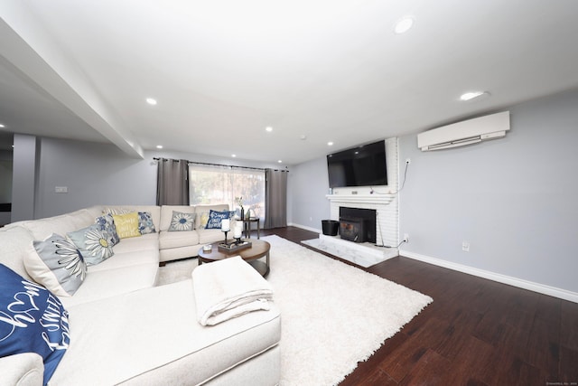 living room featuring a fireplace, dark wood-type flooring, and a wall mounted air conditioner