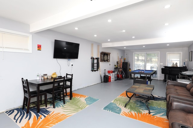 living room featuring beam ceiling, concrete flooring, and billiards