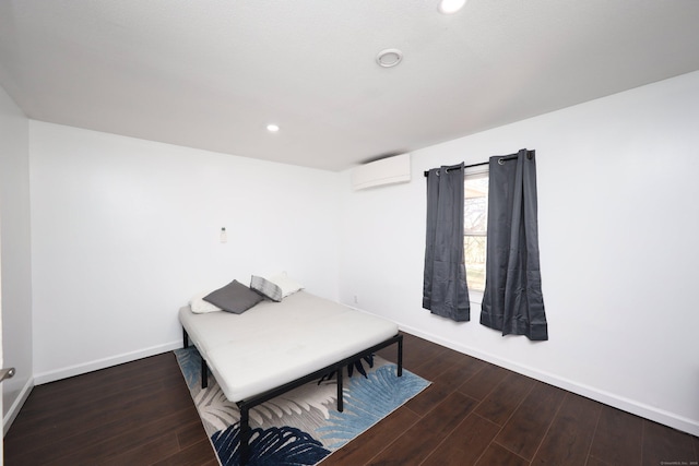 bedroom with an AC wall unit and dark hardwood / wood-style floors