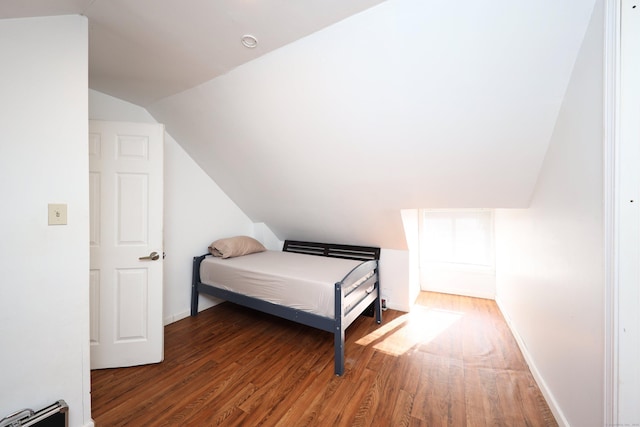 bedroom with hardwood / wood-style floors and lofted ceiling