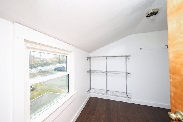 spare room with dark hardwood / wood-style flooring and vaulted ceiling