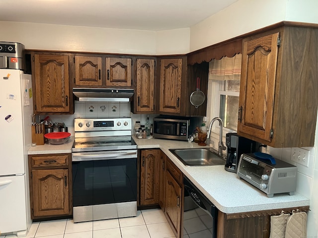 kitchen with decorative backsplash, sink, light tile patterned floors, and stainless steel appliances