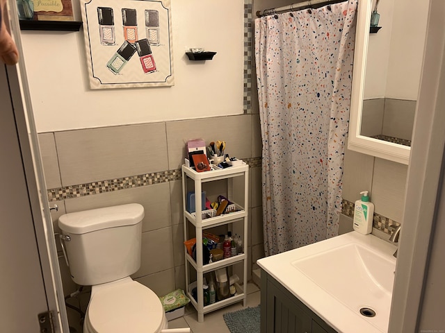 bathroom featuring a shower with shower curtain, vanity, toilet, and tile walls