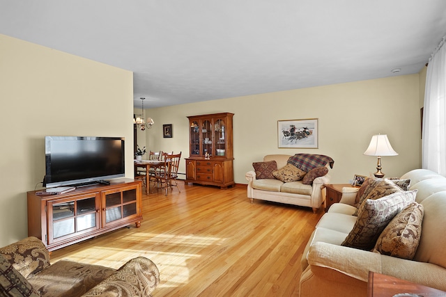 living room with light wood-type flooring and a notable chandelier