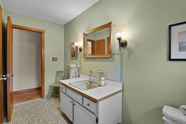 bathroom with toilet, tasteful backsplash, vanity, and tile patterned flooring