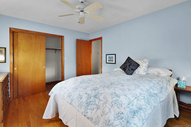 bedroom featuring light hardwood / wood-style floors, ceiling fan, and a closet