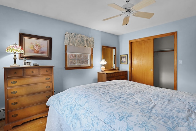 bedroom with hardwood / wood-style flooring, ceiling fan, and a closet