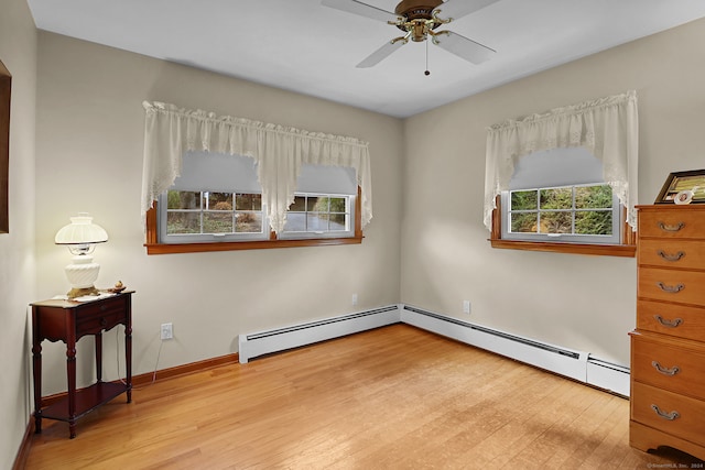 bedroom with multiple windows, light hardwood / wood-style flooring, and a baseboard radiator