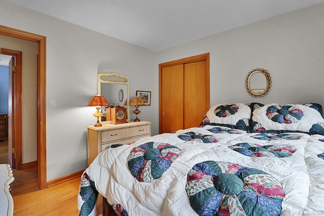 bedroom with light hardwood / wood-style floors and a closet