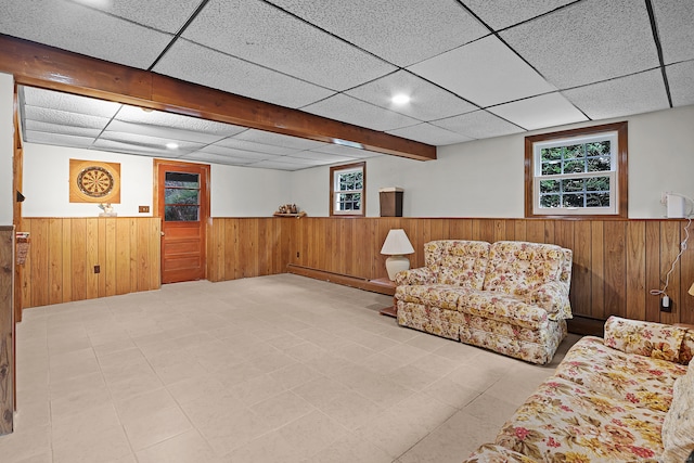 sitting room with a drop ceiling and wooden walls