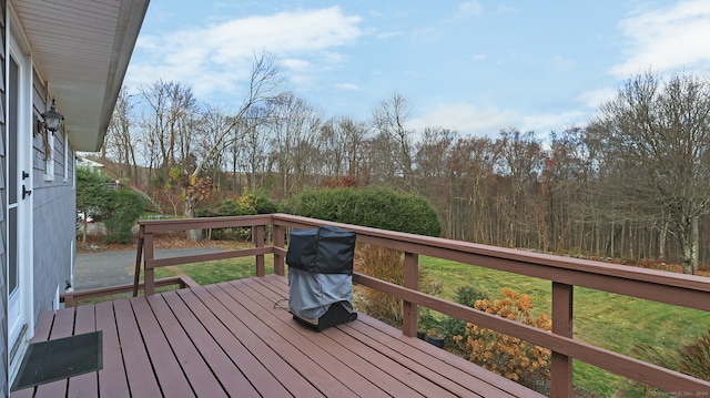 wooden terrace featuring a lawn