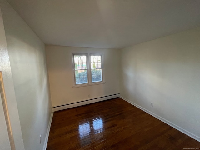 empty room featuring dark hardwood / wood-style floors and baseboard heating