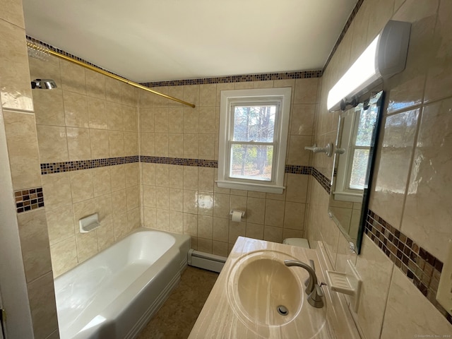 full bathroom featuring vanity, tiled shower / bath combo, a baseboard radiator, tile walls, and toilet