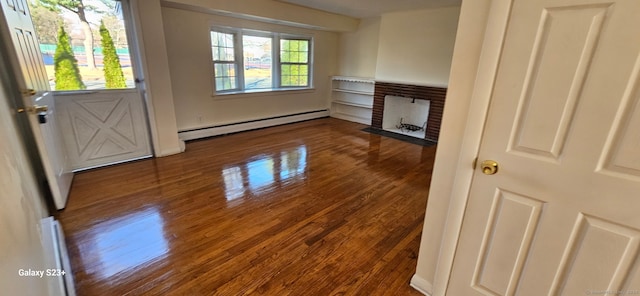 interior space with a baseboard radiator, a brick fireplace, and hardwood / wood-style flooring