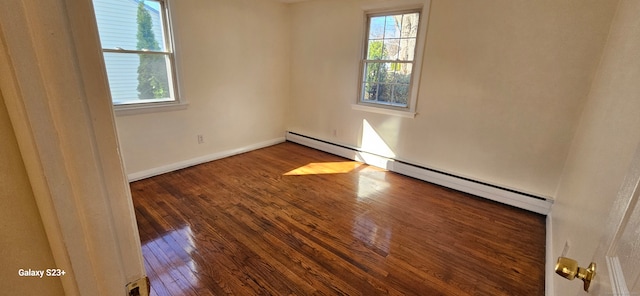 spare room featuring a baseboard radiator and dark wood-type flooring