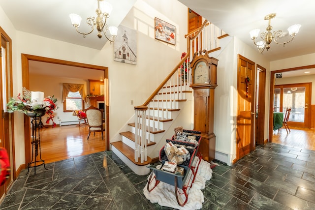 staircase featuring a chandelier, wood-type flooring, baseboard heating, and a healthy amount of sunlight