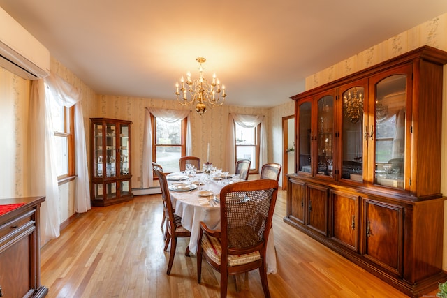 dining space featuring a chandelier, light wood-type flooring, and a baseboard heating unit