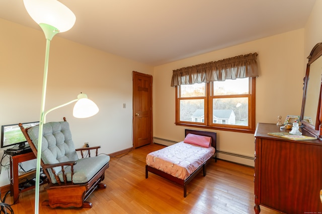 bedroom featuring baseboard heating and light hardwood / wood-style flooring