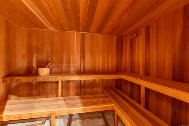 view of sauna featuring wooden ceiling and wooden walls