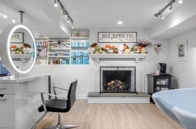 interior space with track lighting, wood finished floors, and a fireplace