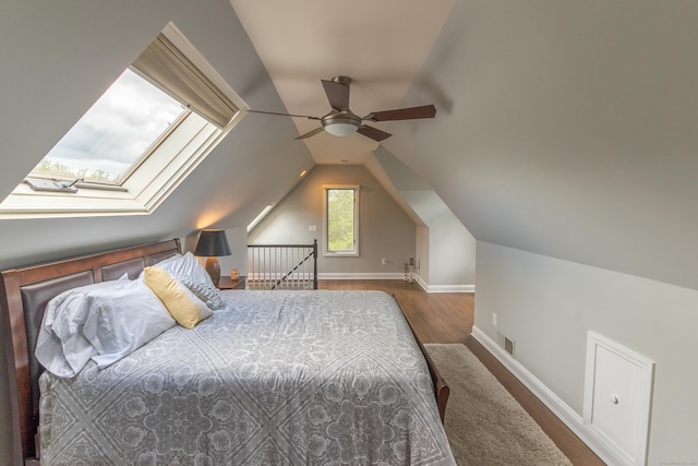 bedroom with visible vents, wood finished floors, baseboards, ceiling fan, and vaulted ceiling