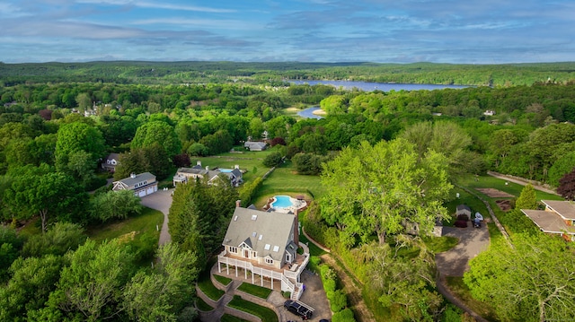 birds eye view of property with a water view and a view of trees