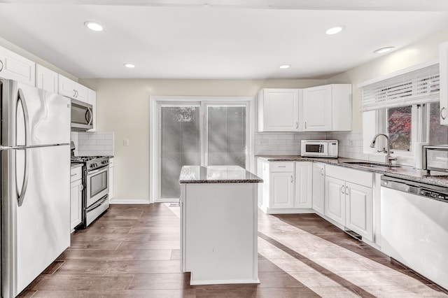 kitchen with appliances with stainless steel finishes, white cabinetry, and sink