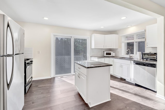 kitchen featuring white cabinets, sink, light hardwood / wood-style floors, a kitchen island, and stainless steel appliances