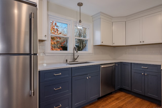 kitchen with stainless steel appliances, white cabinetry, decorative backsplash, sink, and dark wood-type flooring