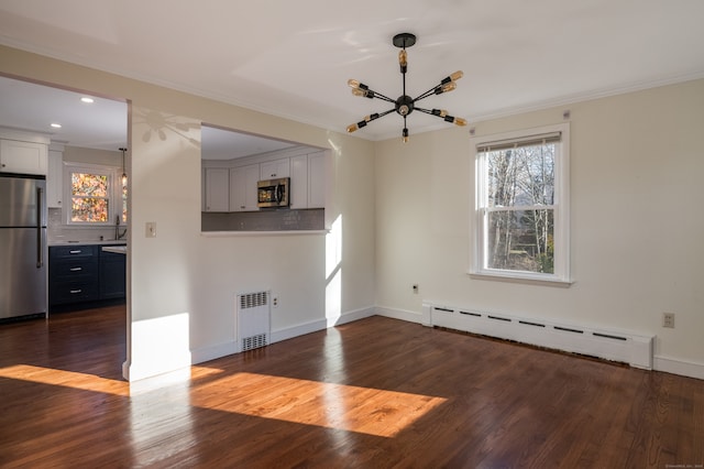 empty room featuring radiator heating unit, ornamental molding, dark hardwood / wood-style floors, sink, and baseboard heating