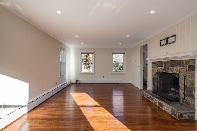 unfurnished living room featuring a baseboard heating unit, dark wood-type flooring, crown molding, and a stone fireplace