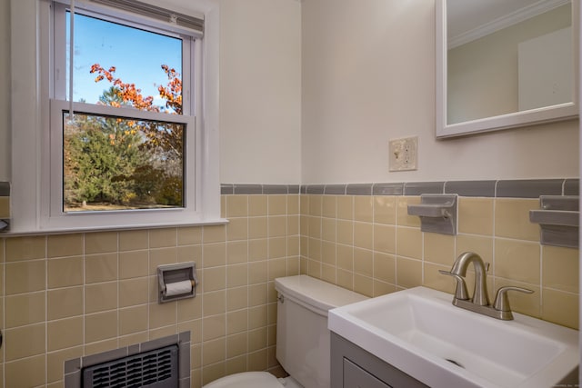 bathroom featuring toilet, vanity, and tile walls