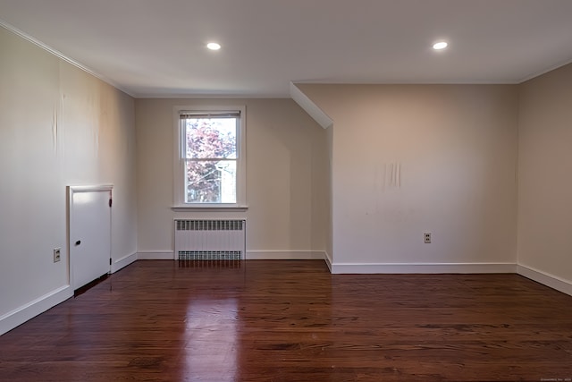 additional living space with dark wood-type flooring and radiator heating unit